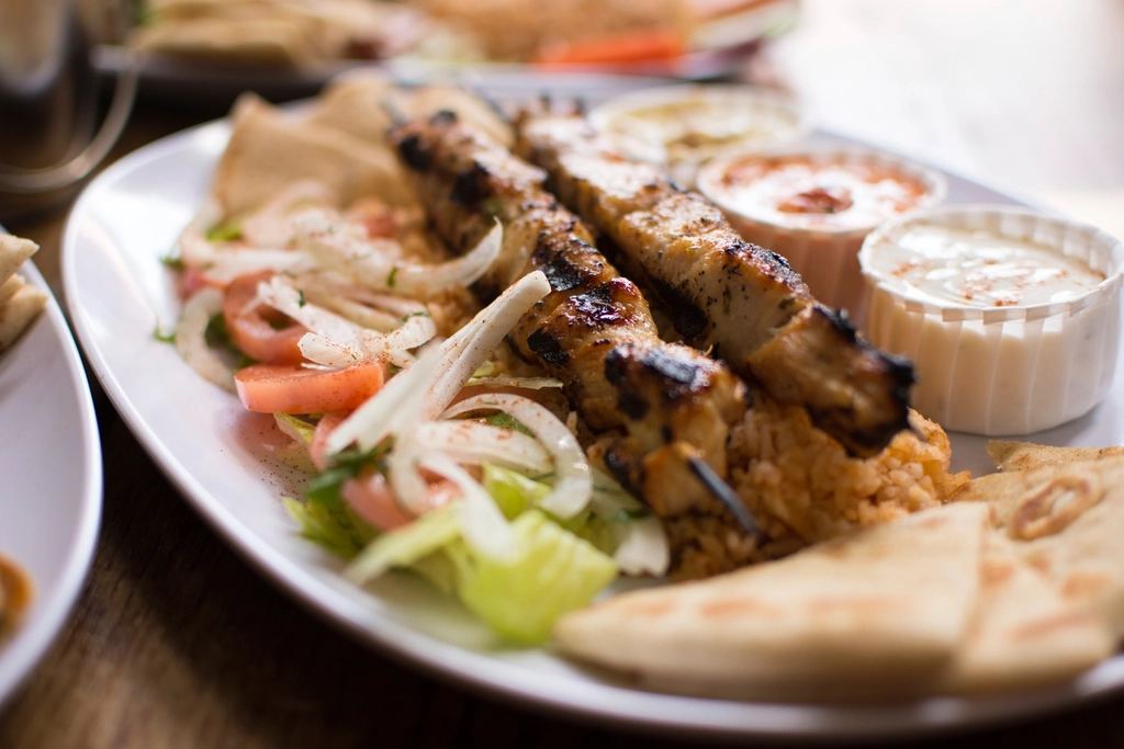 Grilled halal skewers served with flatbread, salad and sauce